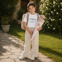 Mädchen trägt personalisiertes Schulkind T-Shirt 2026 mit Namen Sophia und Schultüte im Garten