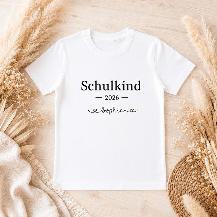 Personalisiertes Schulkind T-Shirt 2026 mit Namen Sophia auf hellem Holzuntergrund mit Trockenblumen